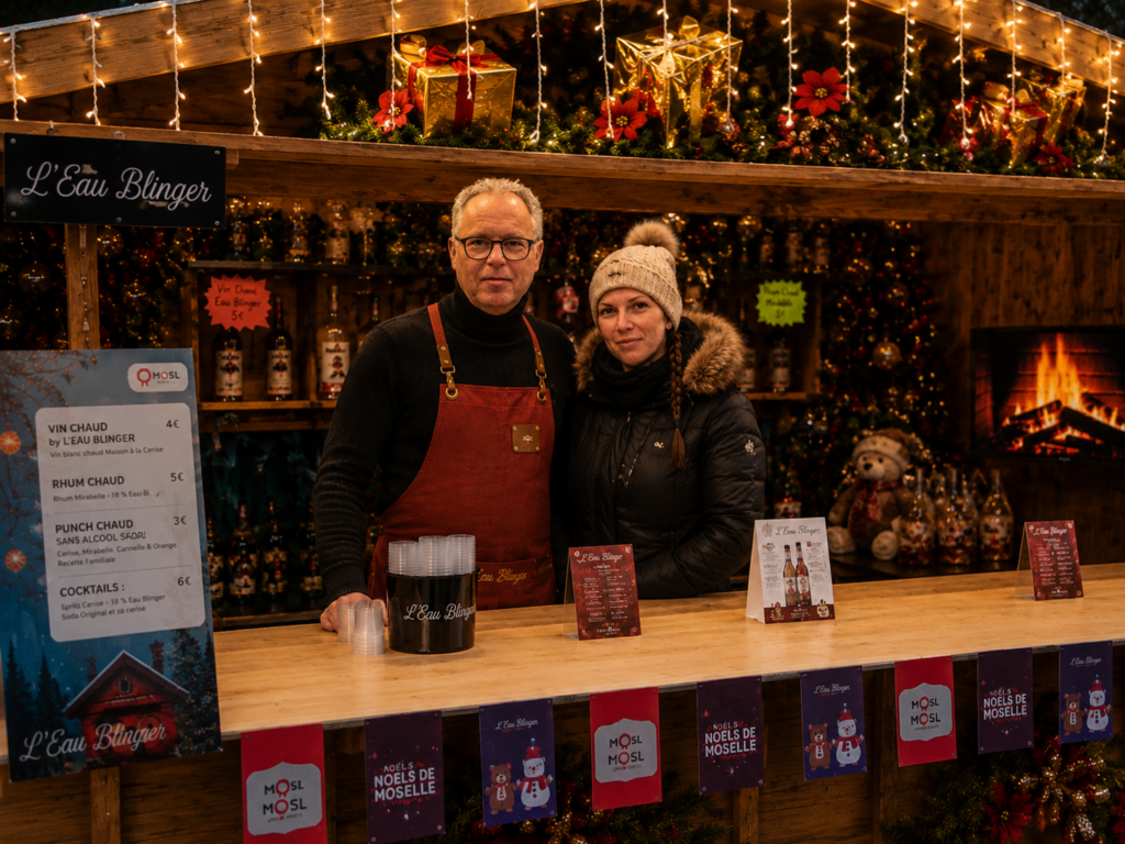 Deux personnes derrière le comptoir d’un chalet décoré pour Noël.